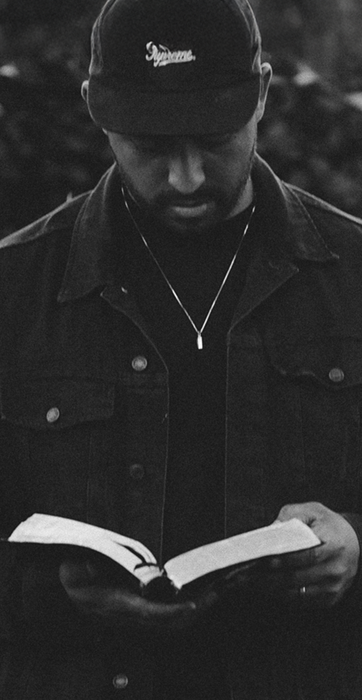 Black and white photo of a Pastor of a Christian church holding and reading his bible. This is an intro to church branding on the header of the BLVR website.